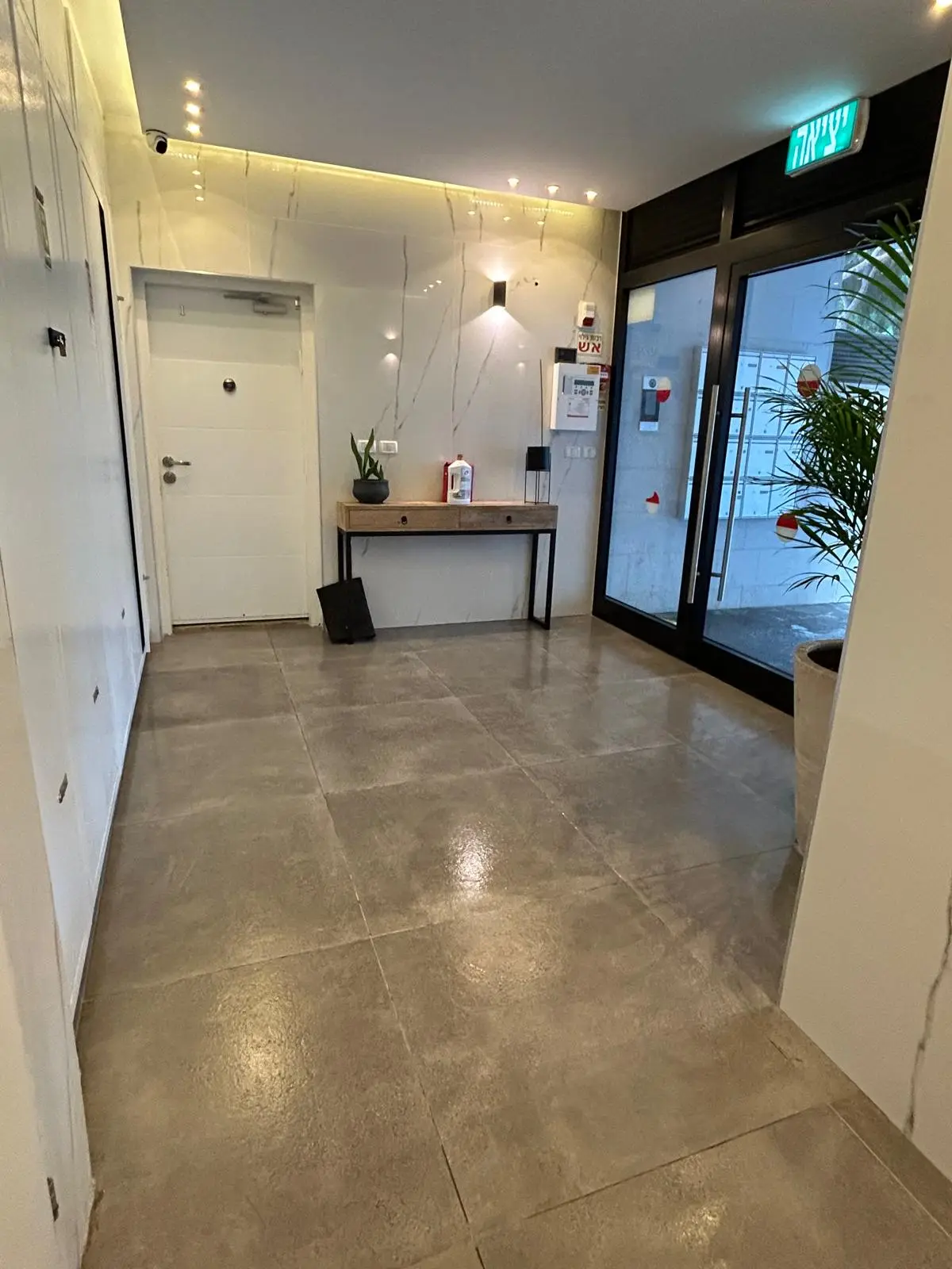 מבואת כניסה בבניין מגורים בקריות אחרי ניקיון: רצפה מלוטשת, תיבות דואר ואזור כניסה מסודר